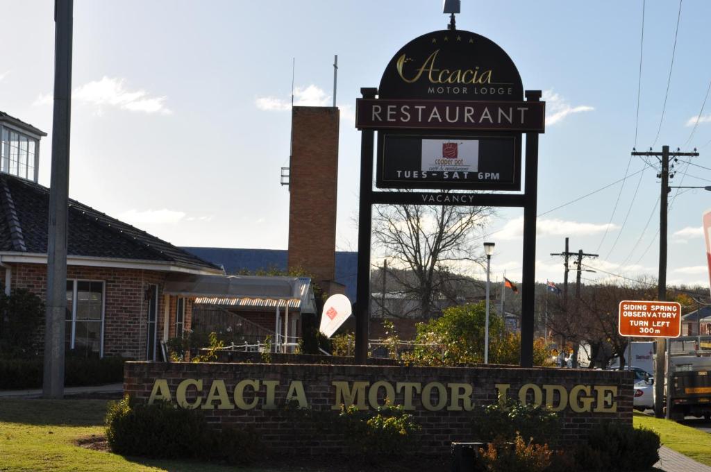 a sign for an acacia morror lodge on a street at Acacia Motor Lodge in Coonabarabran