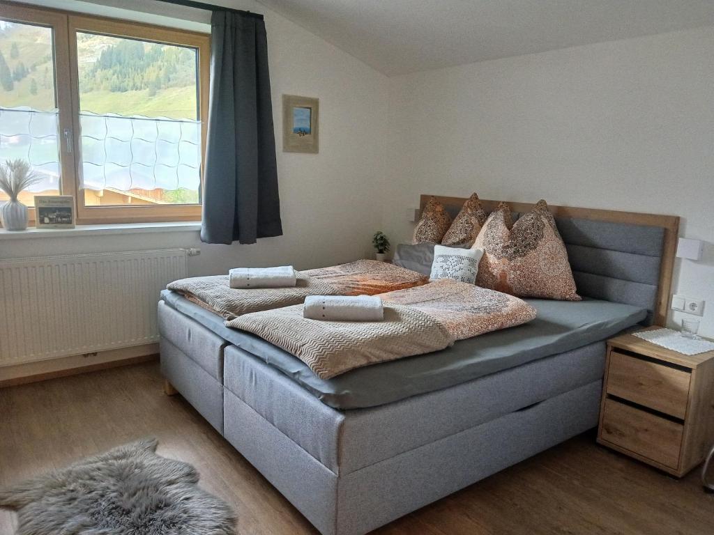a bedroom with a large bed with a window at Kumming incl Nationalparkcard in Rauris