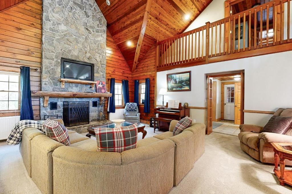 a living room with couches and a stone fireplace at Rivers Bend Retreat in Cavendish