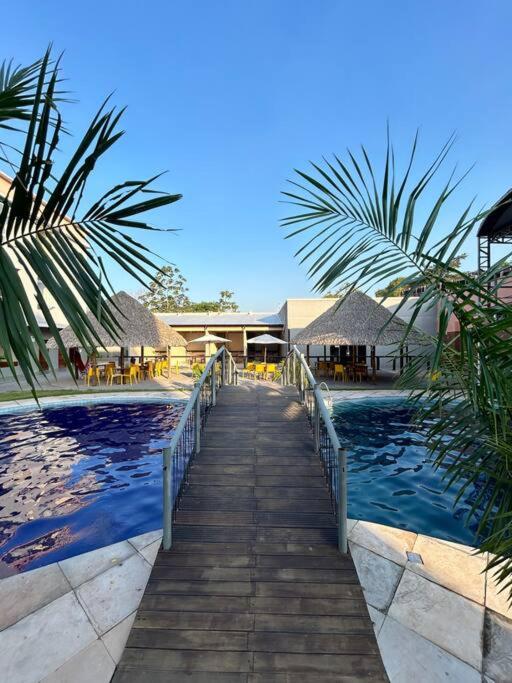 a walkway leading to a resort with a swimming pool at Flat 2 Suítes, piscina e churrasqueira em Alter in Alter do Chao