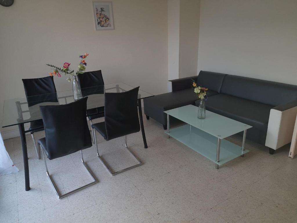 un salon avec un canapé, des chaises et une table dans l'établissement Appartement F3 avec balcon, à Perpignan