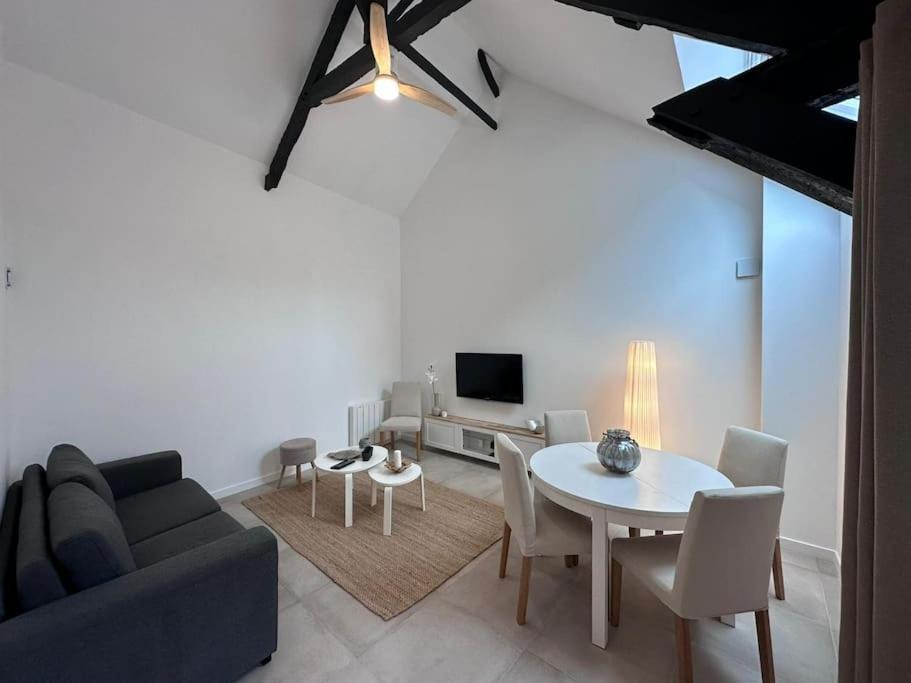 a living room with a couch and a table at Maison de bourg bretonne in Baulon