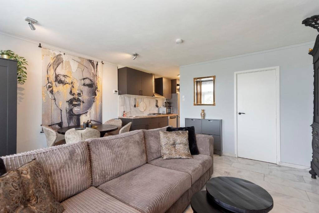 a living room with a couch and a kitchen at De Schelp 58 in Zandvoort