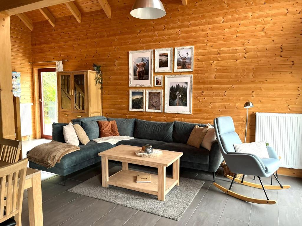 a living room with a couch and a table at 5 Sterne Ferienhaus Annika mit Kamin, Seeblick und großer Terrasse in Rieden