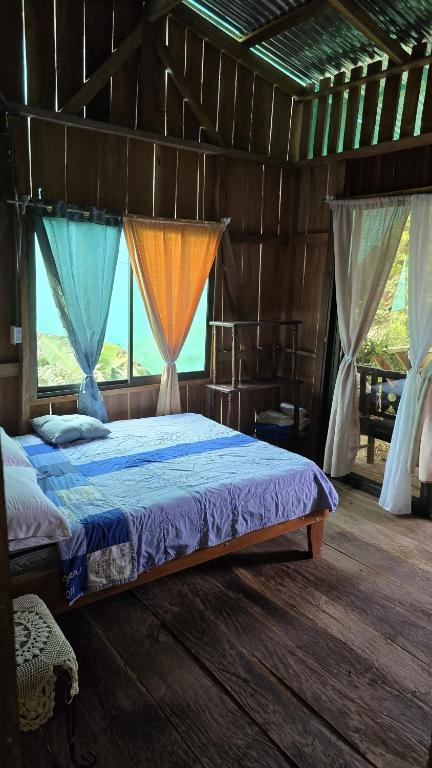 a bedroom with a bed in a room with windows at Landscape-Cabaña Summer-Full Equipada in La Cruz