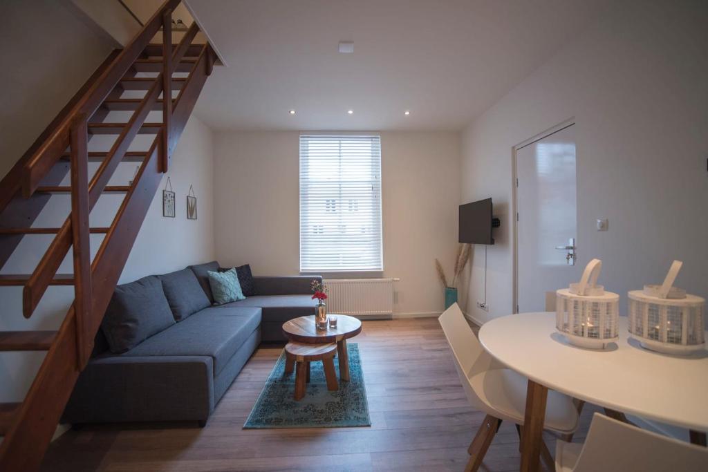 una sala de estar con un sofá y una mesa en Apartment Zandster, en Zandvoort