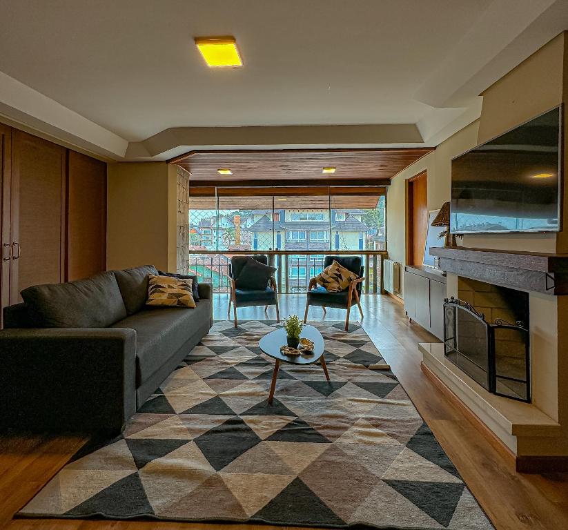 a living room with a couch and a fireplace at Apto Rua Coberta - 3 quartos para 8 pessoas in Gramado