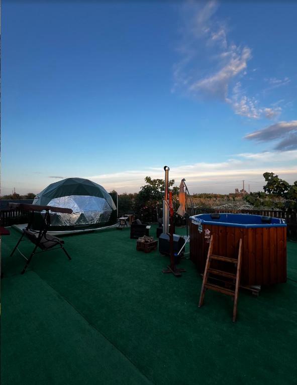 un patio con tenda, tavolo e sedie. di Podere Kiri Dome Experience a Decimomannu