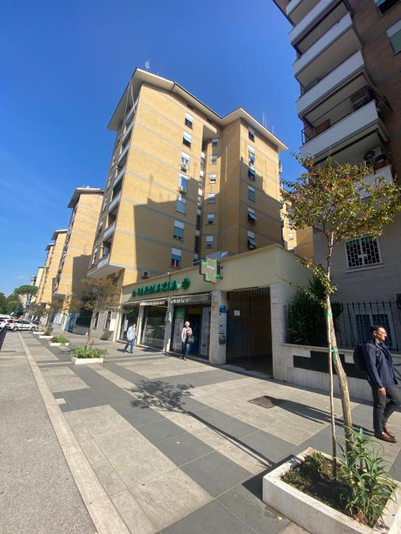 Un uomo in piedi su un marciapiede di fronte a un edificio di Ophele House Rome a Roma