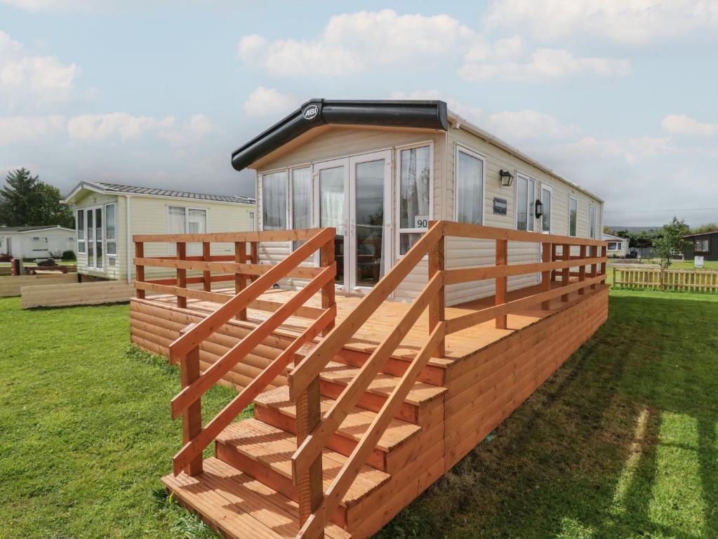 a house with a large deck in the yard at Hazel in Denny
