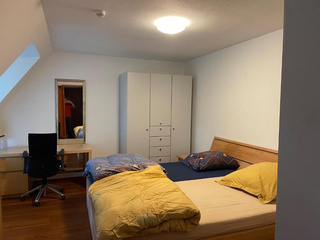 a bedroom with two beds and a desk and a mirror at Kleinmachnow Schlafzimmer mit Schreibtisch und Bad im Flur in Kleinmachnow
