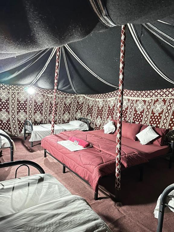 Een bed of bedden in een kamer bij Wahiba Bedouin Rustic Camp