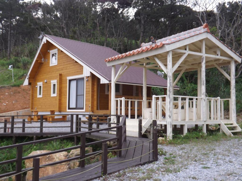 a house with a porch and a gambrel roof at Holiday Home Fu in Nakijin