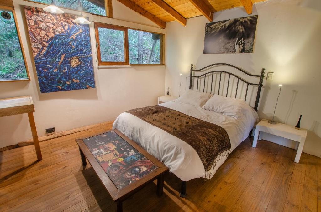 a bedroom with a large bed and paintings on the walls at la casa del sol in San Carlos de Bariloche