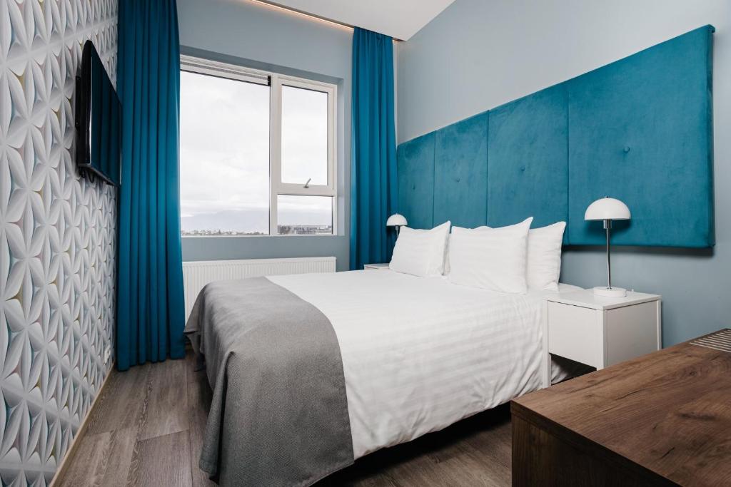 Postel nebo postele na pokoji v ubytování ODDSSON Midtown Hotel