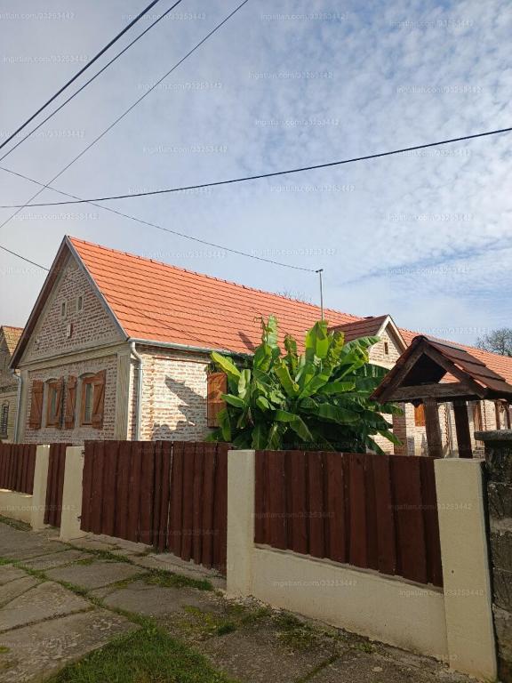a house with a wooden fence in front of it at Dráva Fishing Apartman in Drávakeresztúr