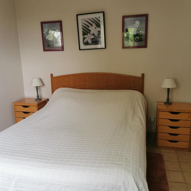 - une chambre avec un lit blanc, 2 tables de nuit et 2 lampes dans l'établissement Dépendance au calme dans notre jardin, à Saint-Aubin-des-Préaux