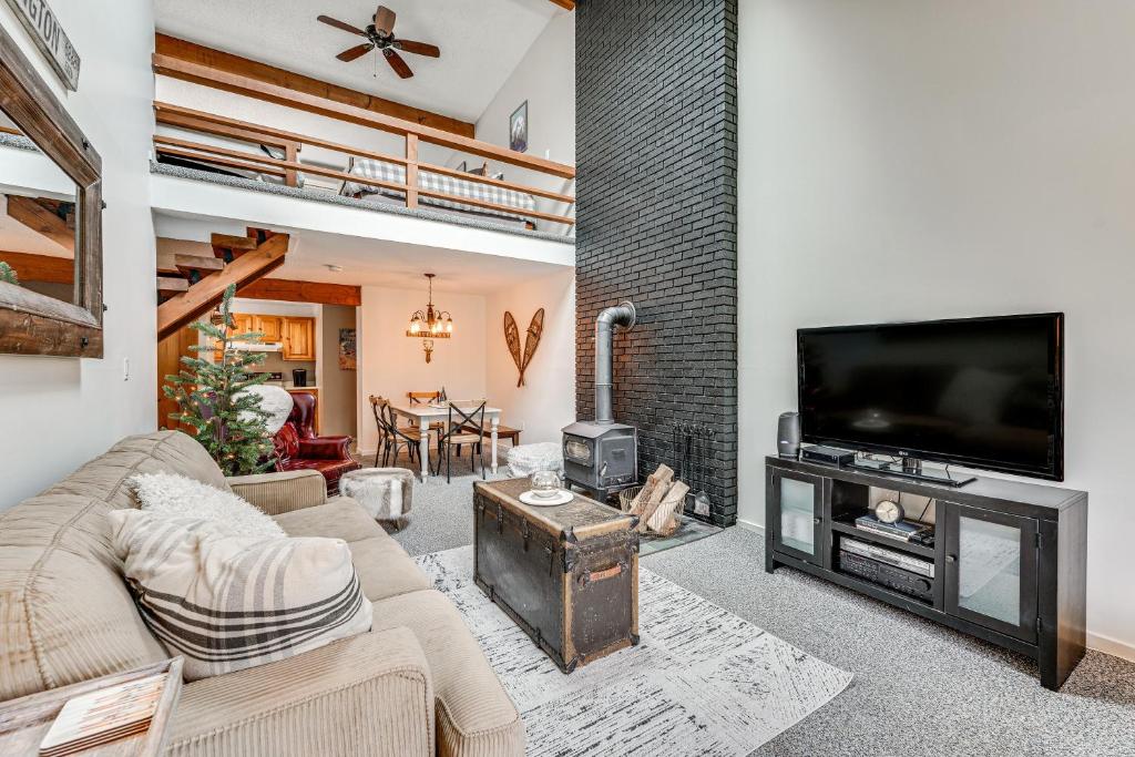 a living room with a fireplace and a tv at Bartlett Condo 1 Mi to Attitash Mountain Resort! in Bartlett