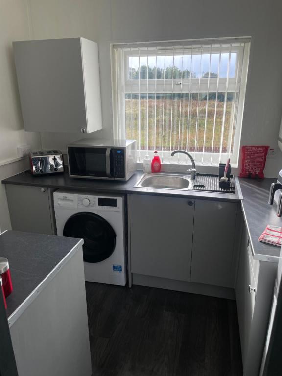 a kitchen with a sink and a washing machine at Modern and Homely Appartment! - Available as individual rooms or the Entire Property! in Bishop Auckland