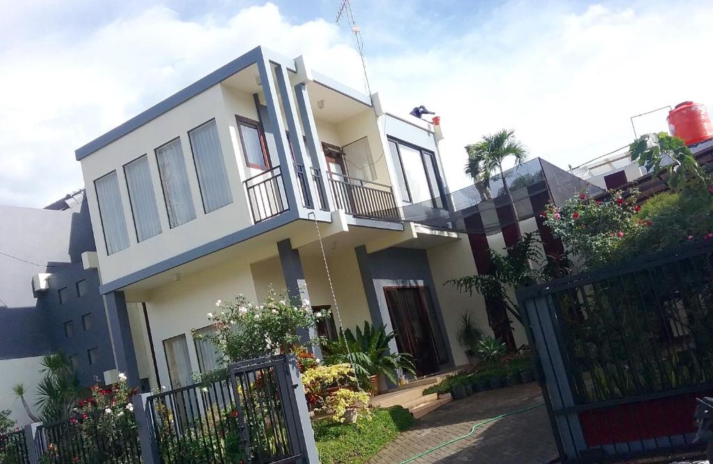 una casa blanca con una puerta y una valla en Sudji's House en Batu