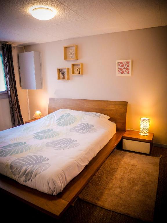 une chambre avec un grand lit avec une tête de lit en bois dans l'établissement Grand appartement au calme, à Lérouville