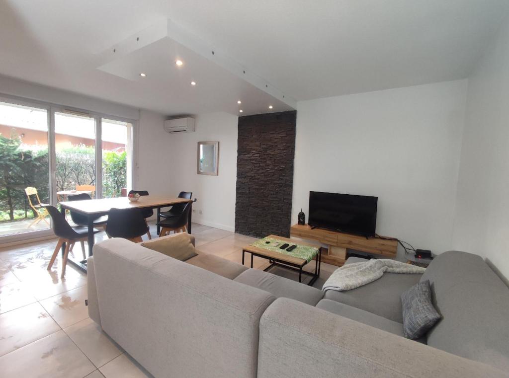 un salon avec un canapé et une table dans l'établissement Superbe appartement, à Aucamville
