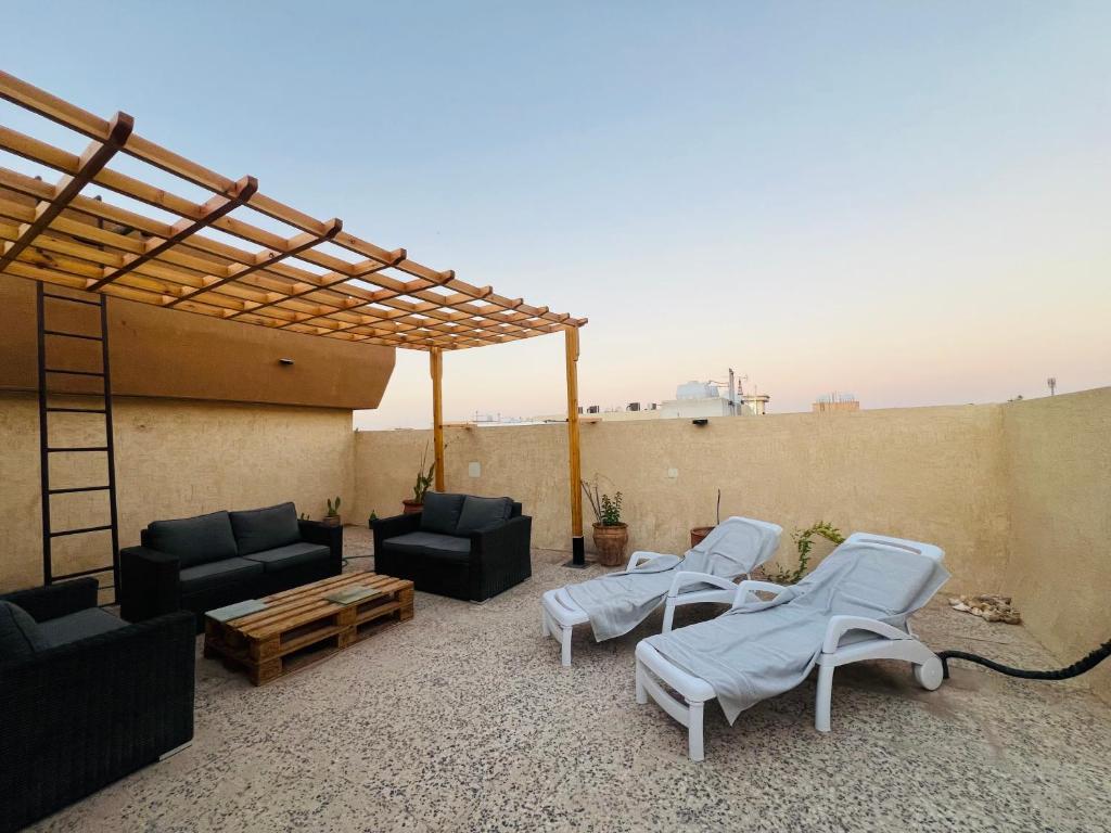 a patio with couches and chairs on a roof at ليالي الخالدية سدو مع دخول ذاتي in Riyadh
