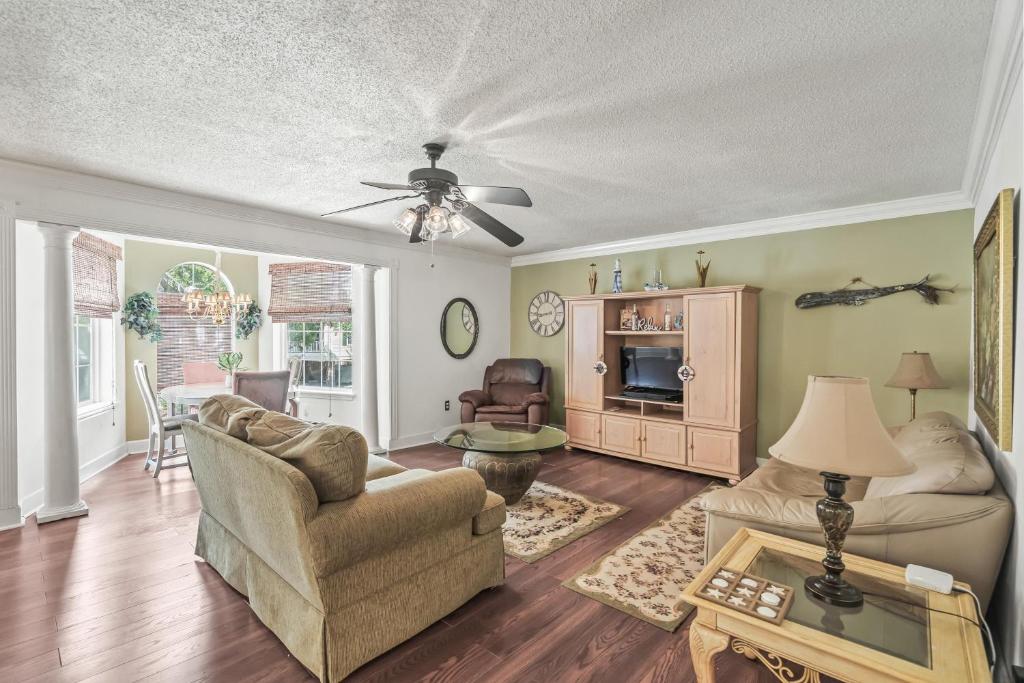 ein Wohnzimmer mit einem Sofa und Stühlen sowie einem Deckenventilator in der Unterkunft Domingos Beach Bungalow- The Coffee House in Myrtle Beach