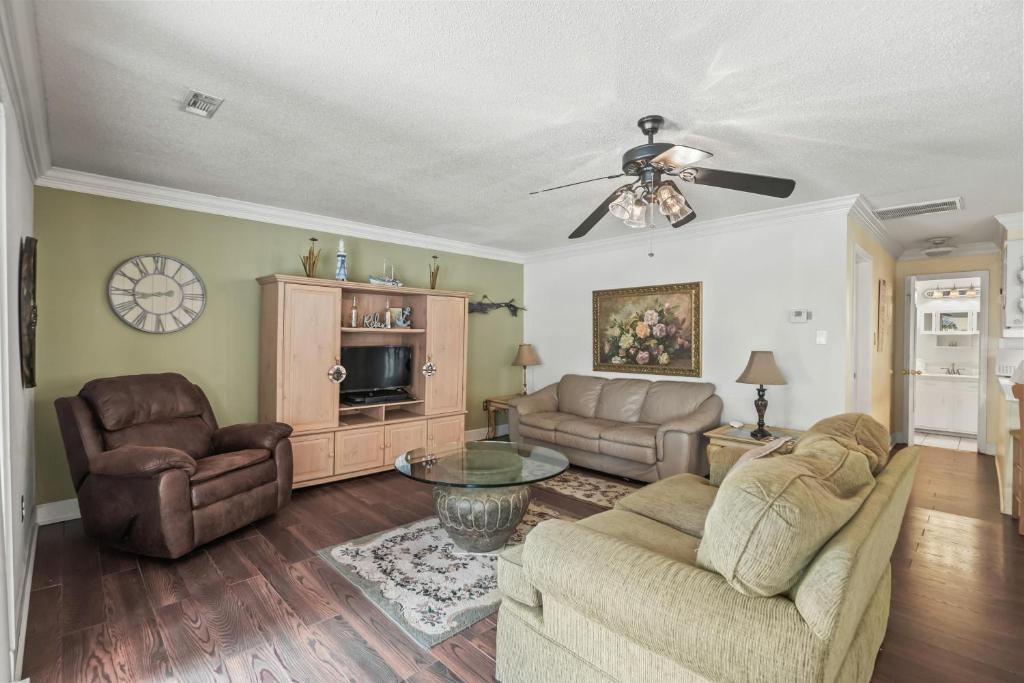 ein Wohnzimmer mit zwei Sofas und einem Fernseher in der Unterkunft Domingos Beach Bungalow- The Coffee House in Myrtle Beach