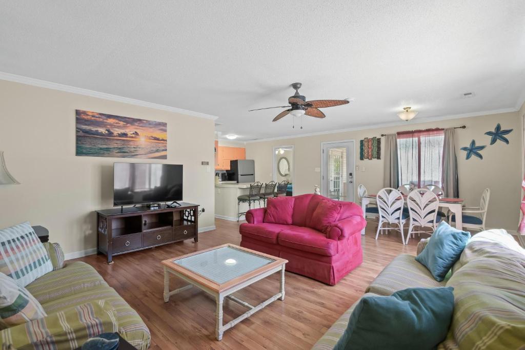 ein Wohnzimmer mit einer Couch und einem Tisch in der Unterkunft Domingos Beach Bungalow- Surfs Up in Myrtle Beach