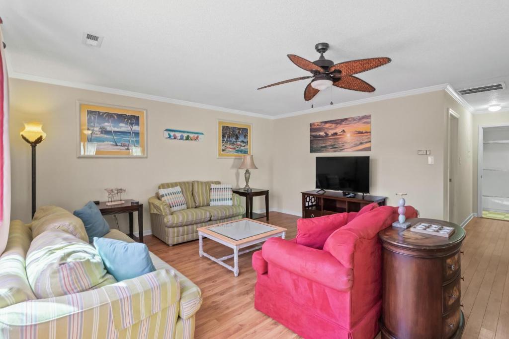 ein Wohnzimmer mit 2 Sofas und einem Deckenventilator in der Unterkunft Domingos Beach Bungalow- Surfs Up in Myrtle Beach