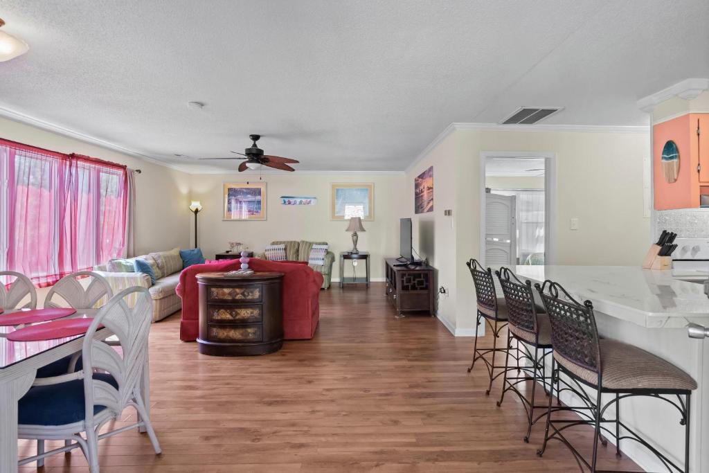 ein Wohnzimmer mit einem roten Sofa und Stühlen in der Unterkunft Domingos Beach Bungalow- Surfs Up in Myrtle Beach