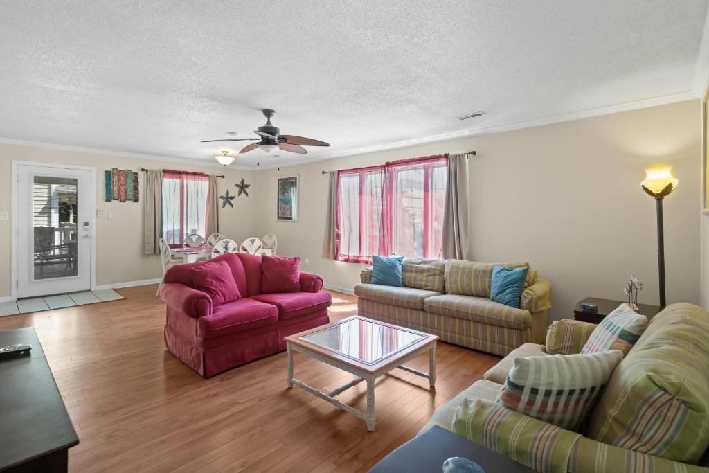 ein Wohnzimmer mit zwei Sofas und einem Tisch in der Unterkunft Domingos Beach Bungalow- Surfs Up in Myrtle Beach