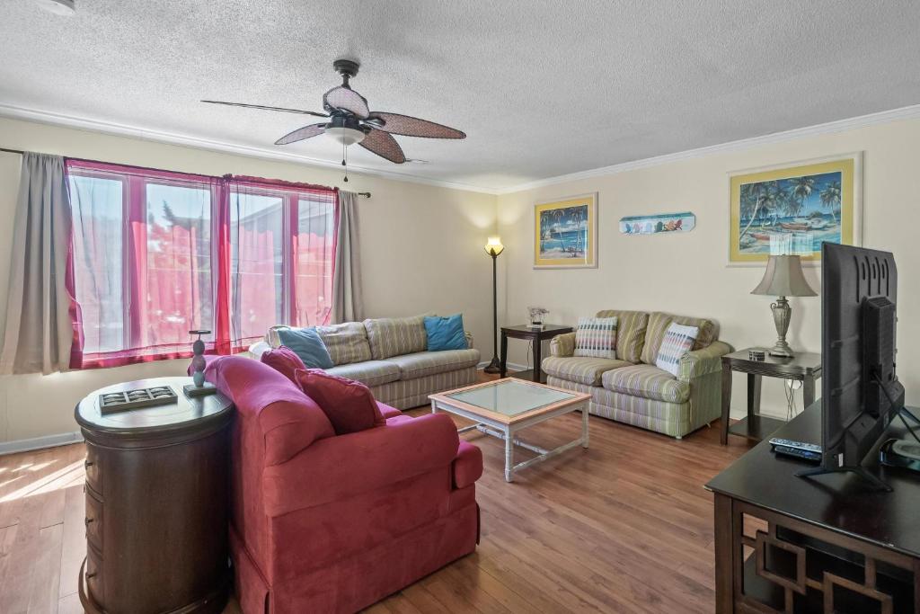 ein Wohnzimmer mit Couch und Fernseher in der Unterkunft Domingos Beach Bungalow- Surfs Up in Myrtle Beach