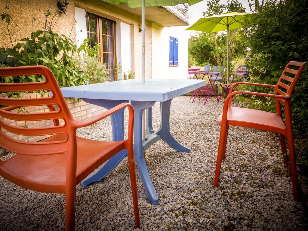 a table and two chairs and an umbrella on a patio at Grand appartement au calme in Lérouville