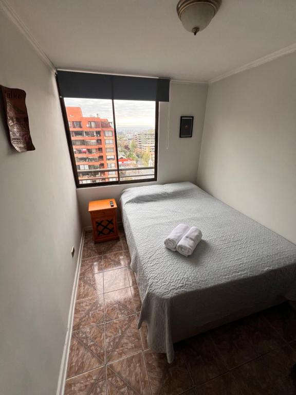 a bedroom with a bed and a large window at Dept Hermosa Vista, Las Condes in Santiago