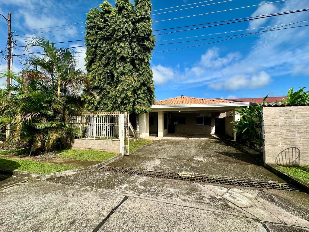 uma casa com um portão e uma árvore em Casa Doleguita em David