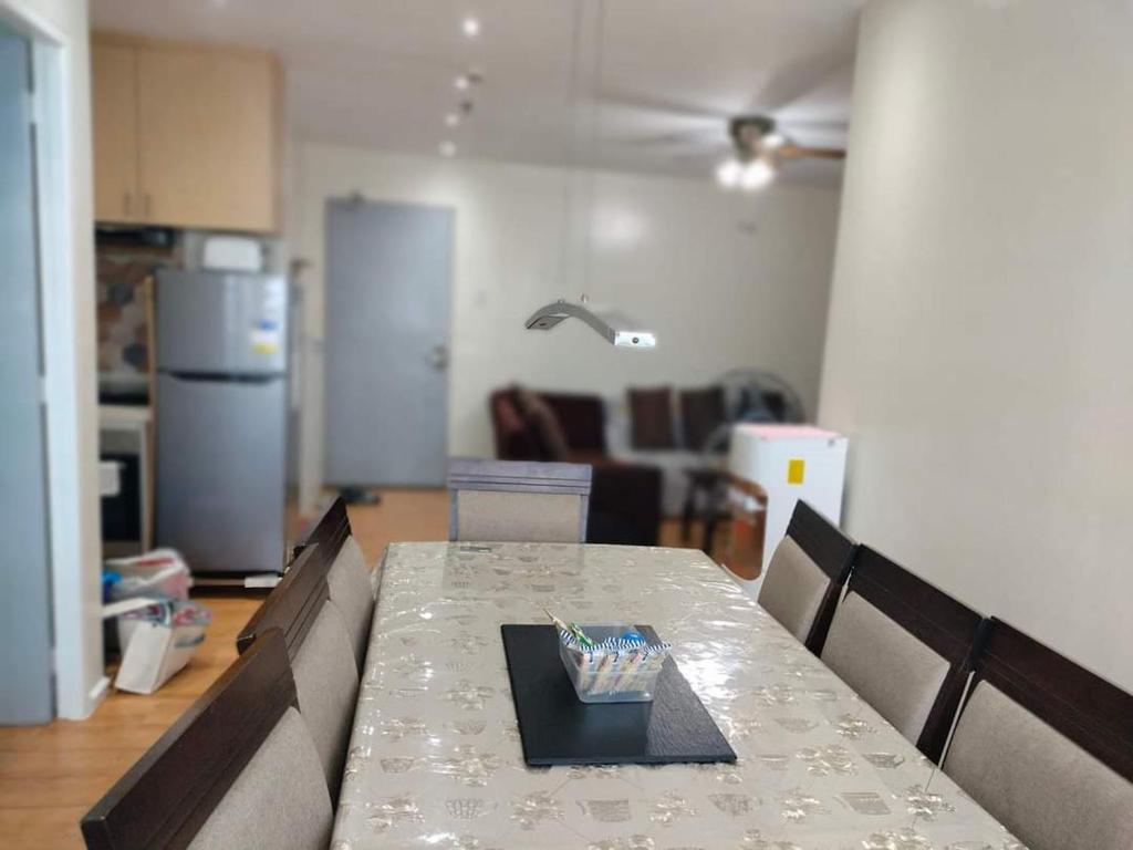 a dining table in a living room with a kitchen at Seawind condo in Davao City