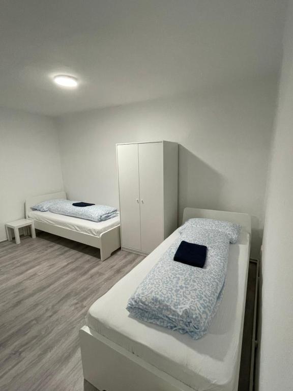 two beds in a room with white walls at Ferien Wohnung Kassel Cassel Zentral in Kassel