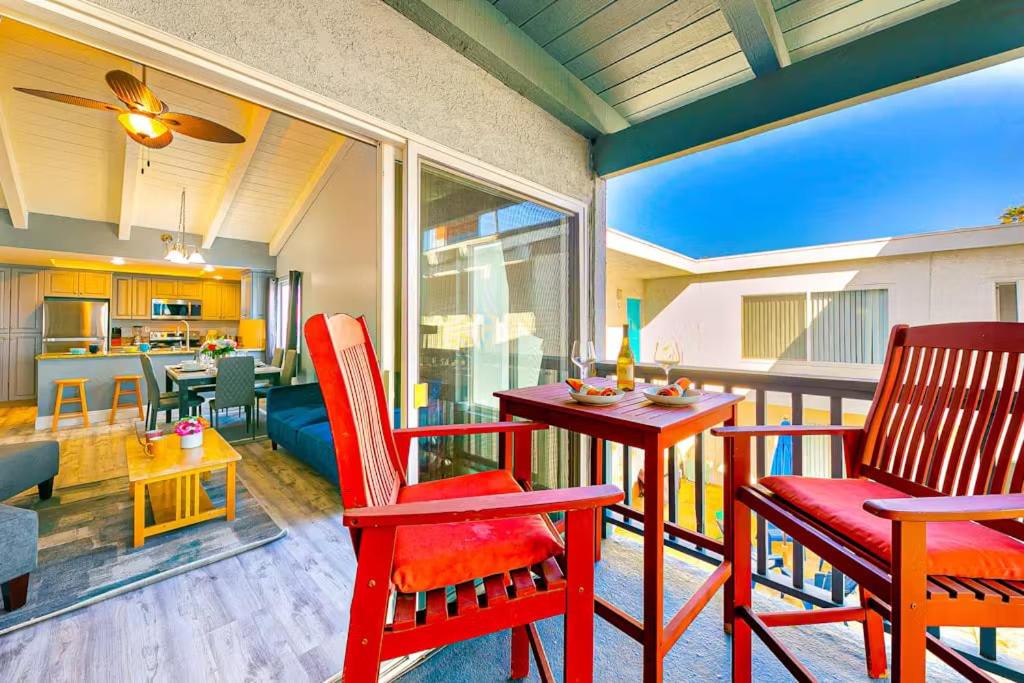 a living room with red chairs and a table at Balboa Peninsula Hidden Gem with Private Balcony & Stunning Views in Newport Beach