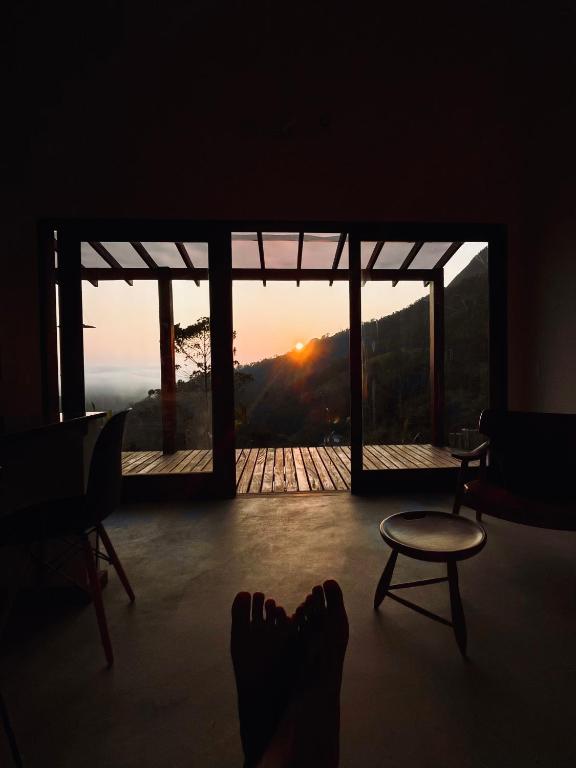 a person with their feet up in a room with a view at Refúgio entre Mar e Montanha in Paraty
