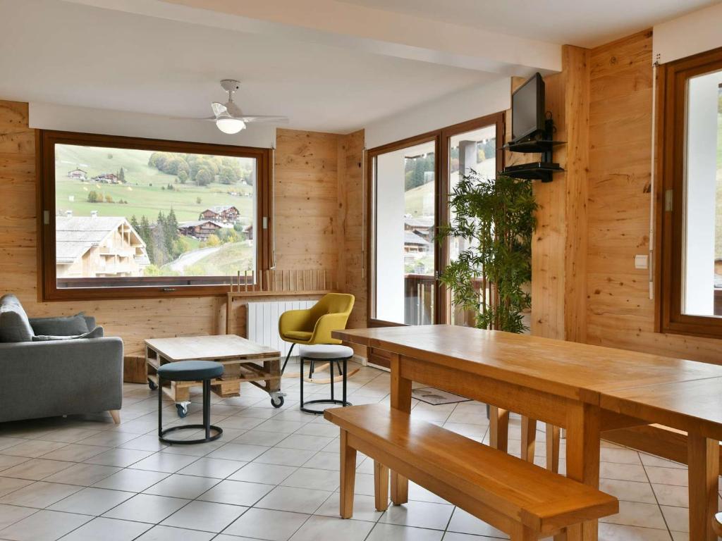 - un salon avec une grande table et des chaises en bois dans l'établissement Confortable appart 6-8 pers au pied des pistes, centre Chinaillon - FR-1-467-131, au Grand-Bornand
