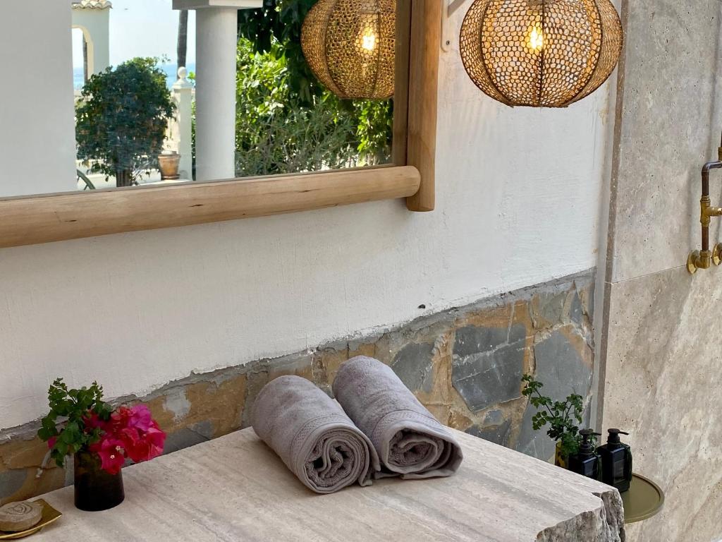 ein Stapel Handtücher auf einem Tisch unter einem Spiegel in der Unterkunft Casa de Colina - great seaview - Marbella in Marbella