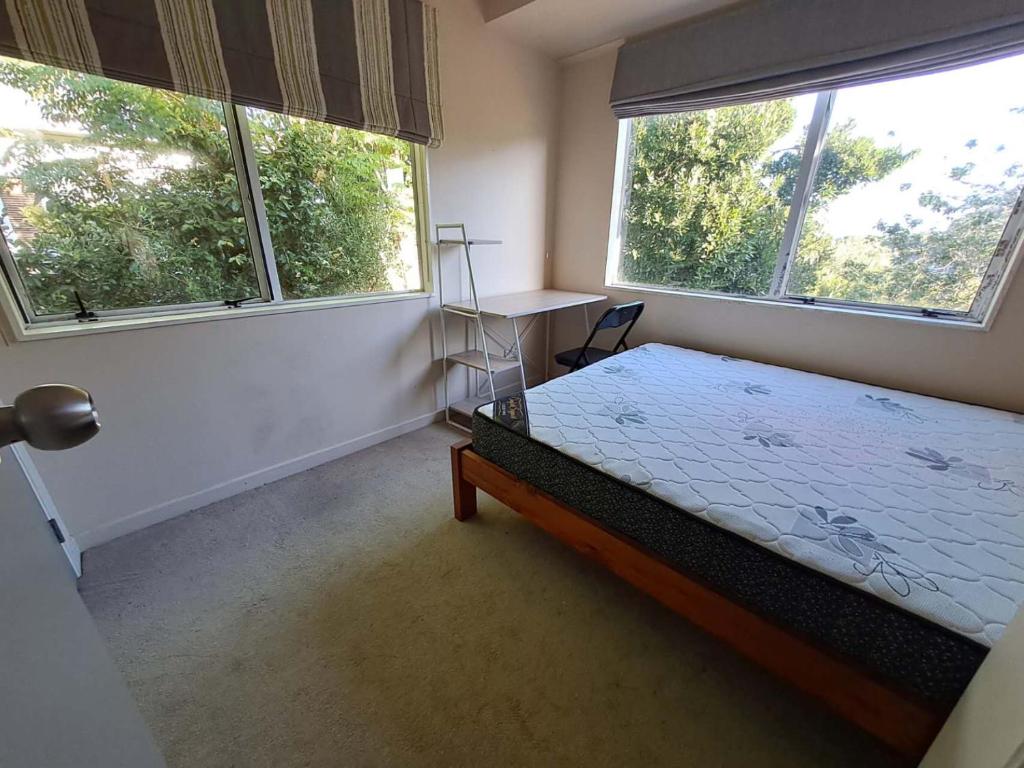 une chambre avec un lit et deux grandes fenêtres dans l'établissement In Remuera with free street carpark, handy close to cuisine restaurant and public transportation, à Auckland
