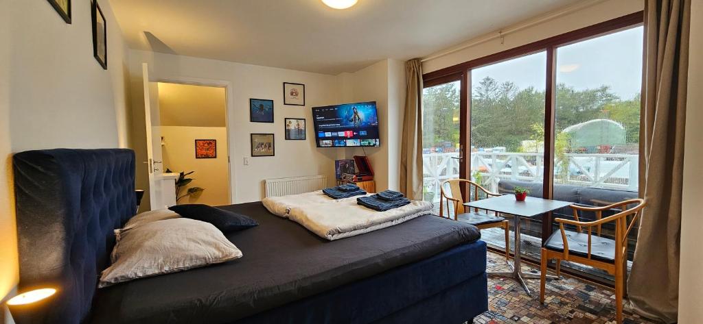 a room with a bed and a table and a television at Olsson B&amp;B in Randers
