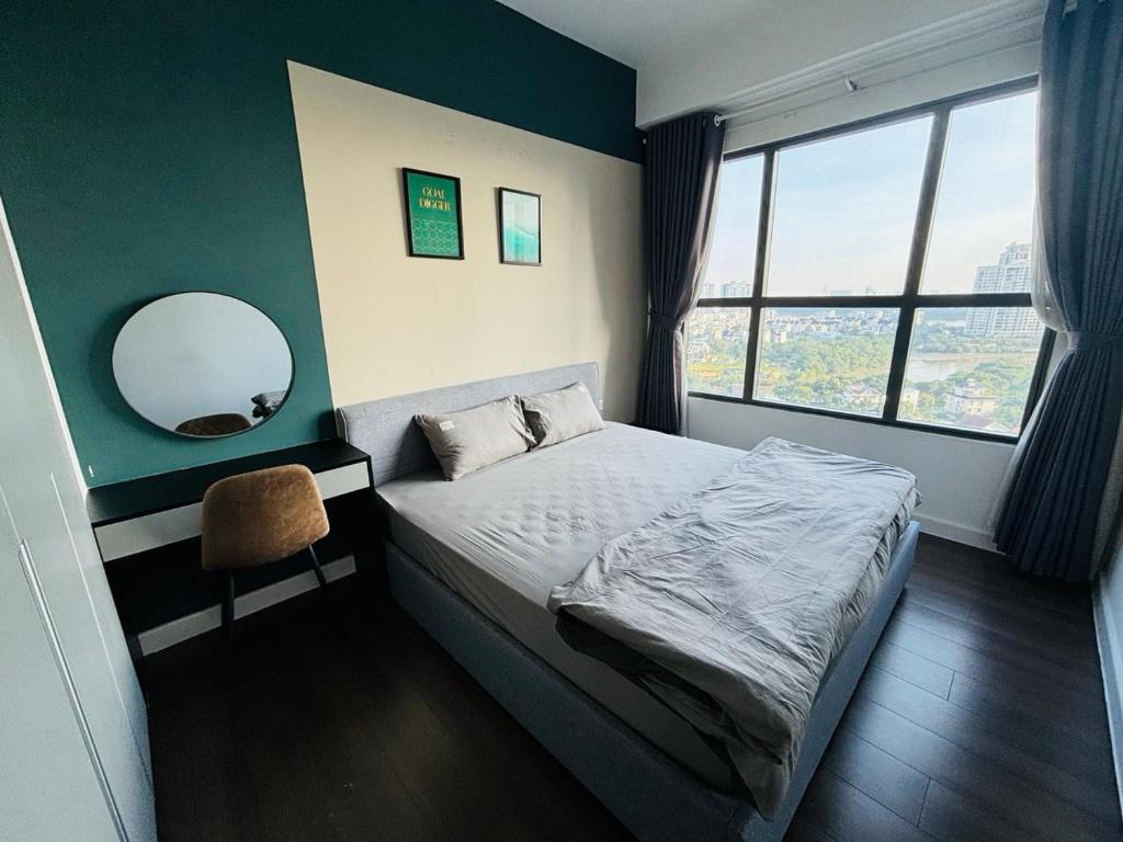 a small bedroom with a bed and a mirror at Sun Avenue - Cozy apartment with river view in Ho Chi Minh City
