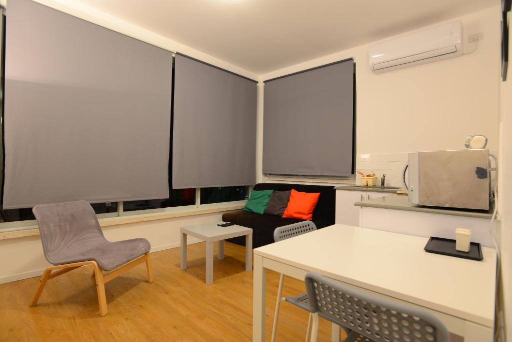 a living room with a table and chairs and windows at Arlozorov Bat Yam Beach in Bat Yam