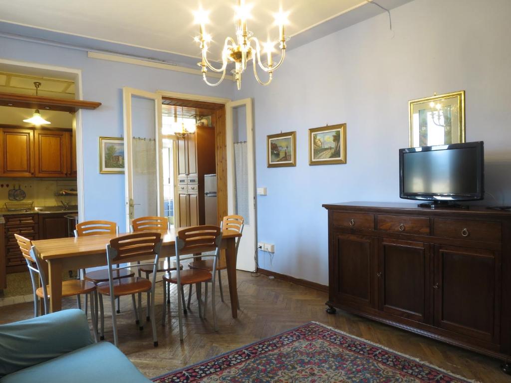 a dining room with a table with chairs and a television at Appartamento in zona storica in Battaglia Terme