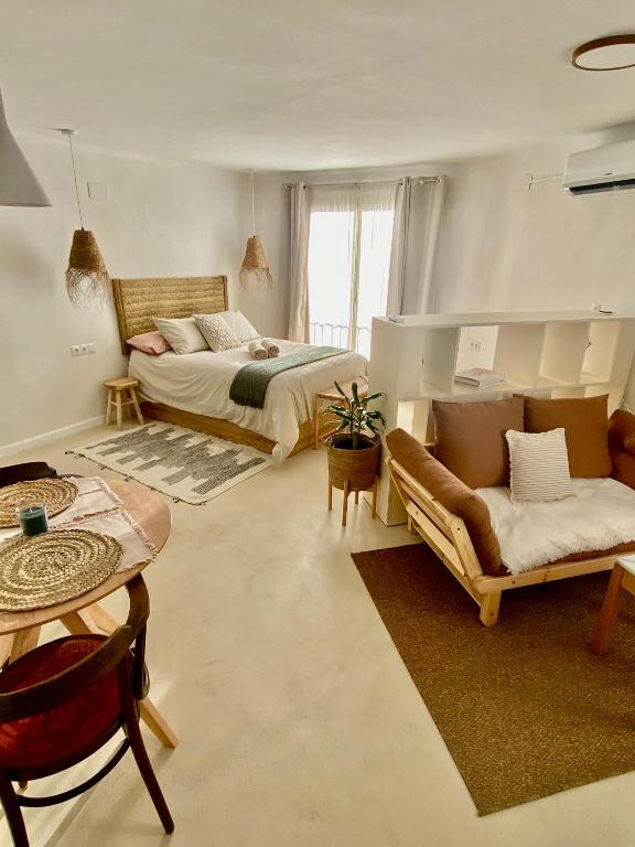 a bedroom with a bed and a couch and a table at Casa Forta, charm between vines in Capmany