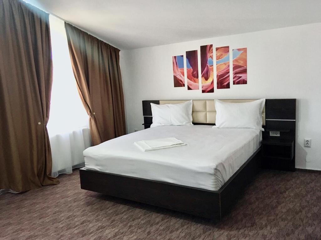 a bedroom with a large bed with white sheets at Will House in Mamaia Nord